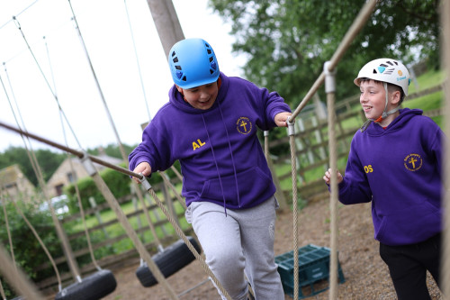 Youth walking on rope bridge