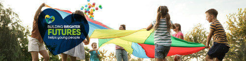 Banner image of children standing a circle holding a large multi-coloured sheet.