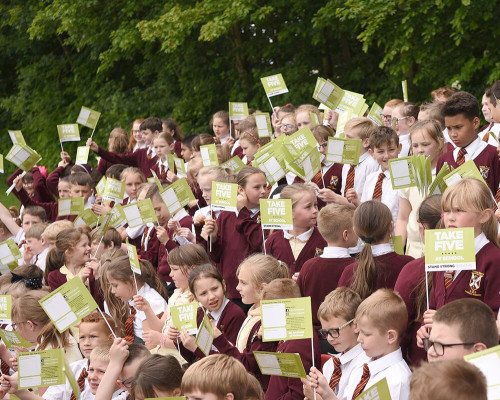 Group of school children holding 'Take Five' signs